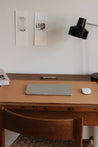 Eine Leder Schreibtischunterlage in Natural liegt auf einem Schreibtisch aus Holz und darauf befindet sich ein zugeklapptes MacBook und eine Maus.