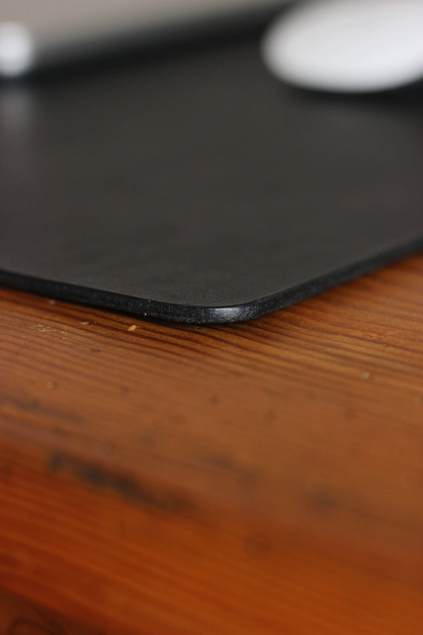 Nahaufnahme der Kante einer Leder Schreibtischunterlage in Schwarz.