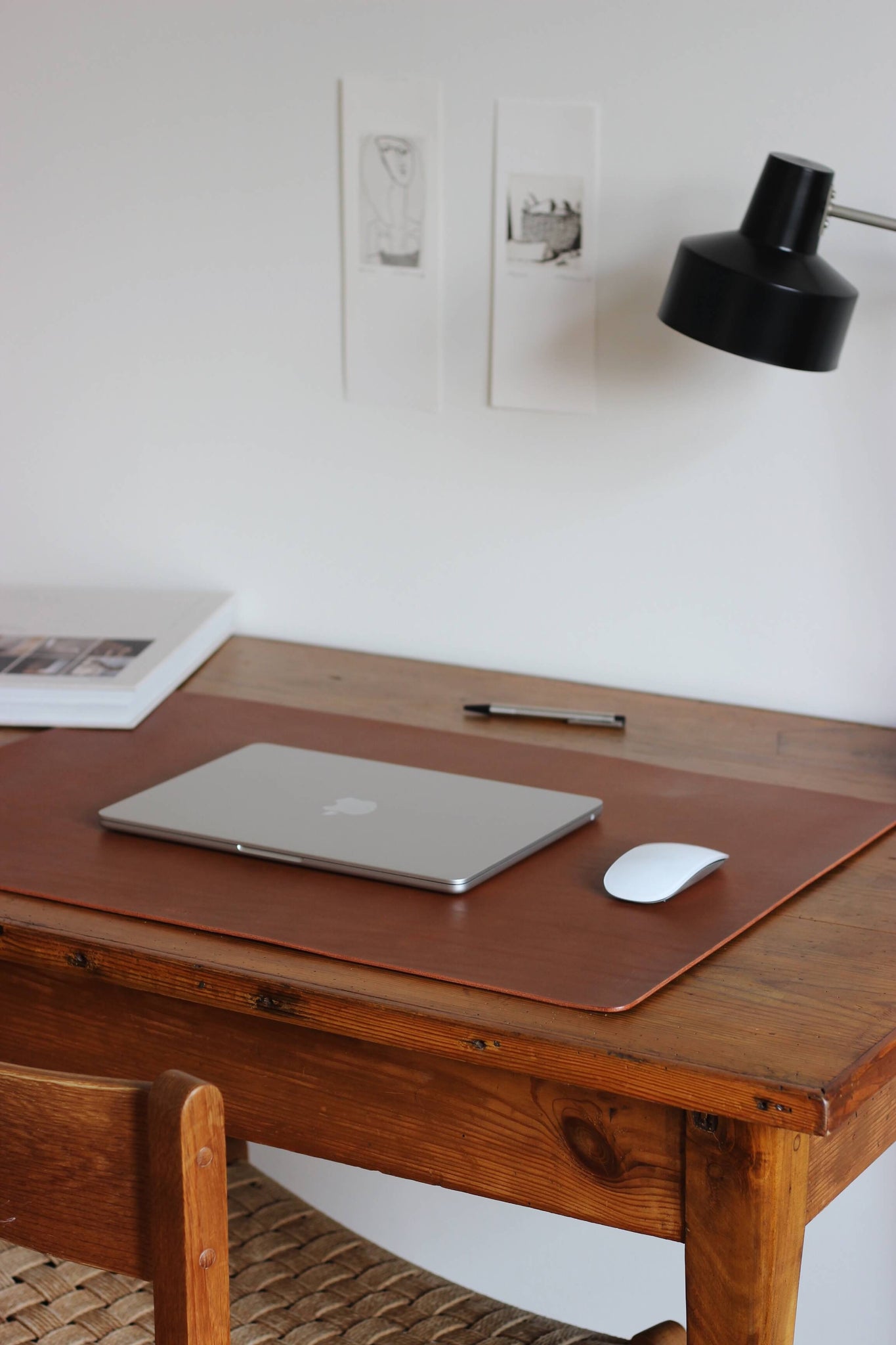 Seitliche Aufnahme einer Leder Schreibtischunterlage in Braun auf einem Schreibtisch.