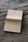 Rückseite eines Leder Kartenetuis in Natural auf einer Holzplatte.