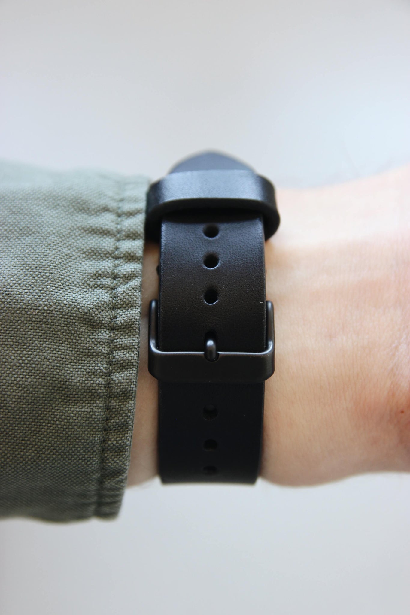 Rückansicht eines Apple Watch Lederbands in Schwarz am Handgelenk.