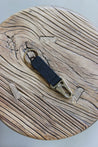 Ein Leder Schlüsselanhänger in Schwarz mit einem Karabiner und Schlüsselring in Messing Antik auf einem Holzstuhl.