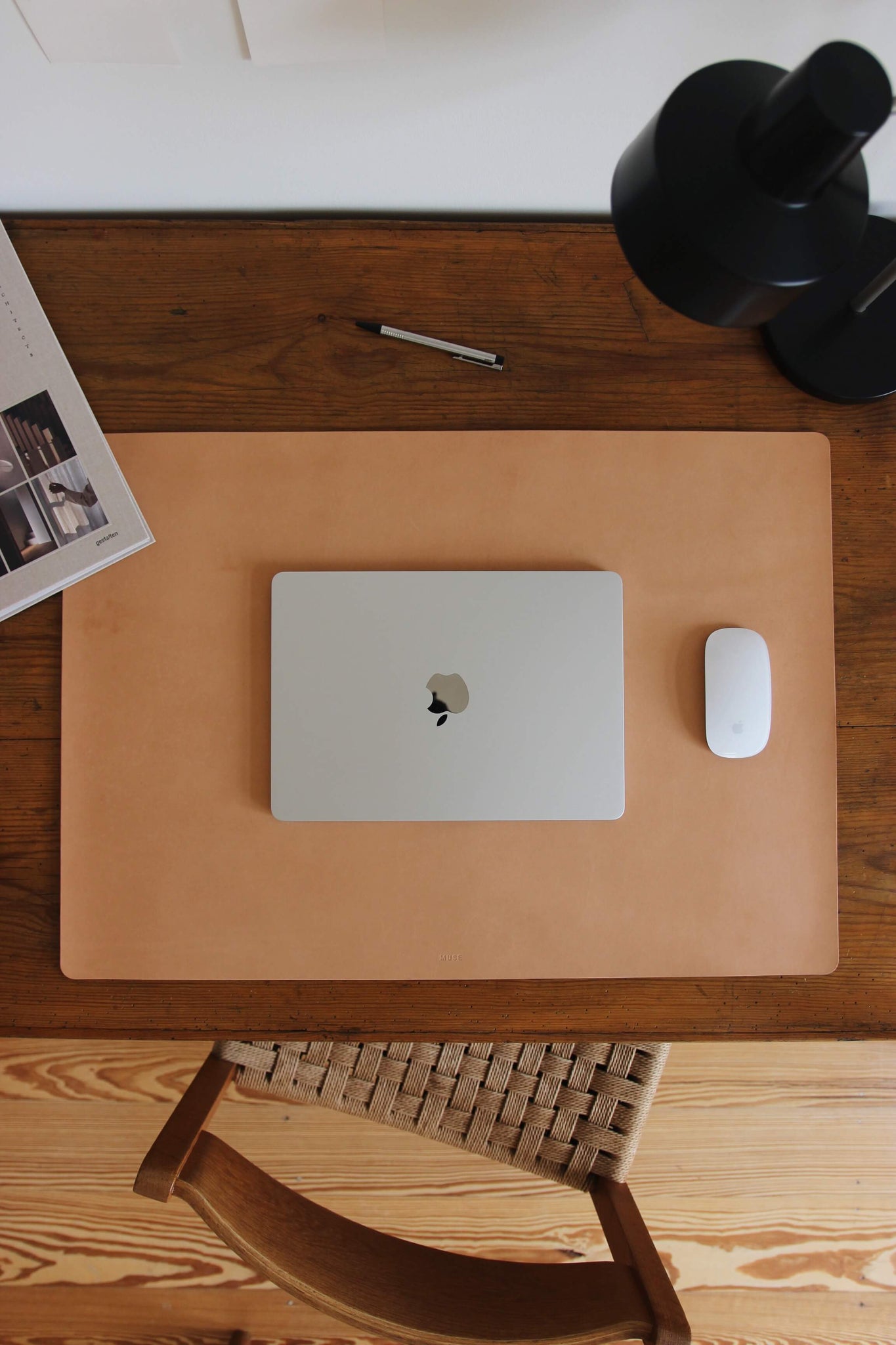 Leder Schreibtischunterlage in Natural auf einem Schreibtisch aus Holz und auf dieser befindet sich ein zugeklapptes MacBook und eine Maus.