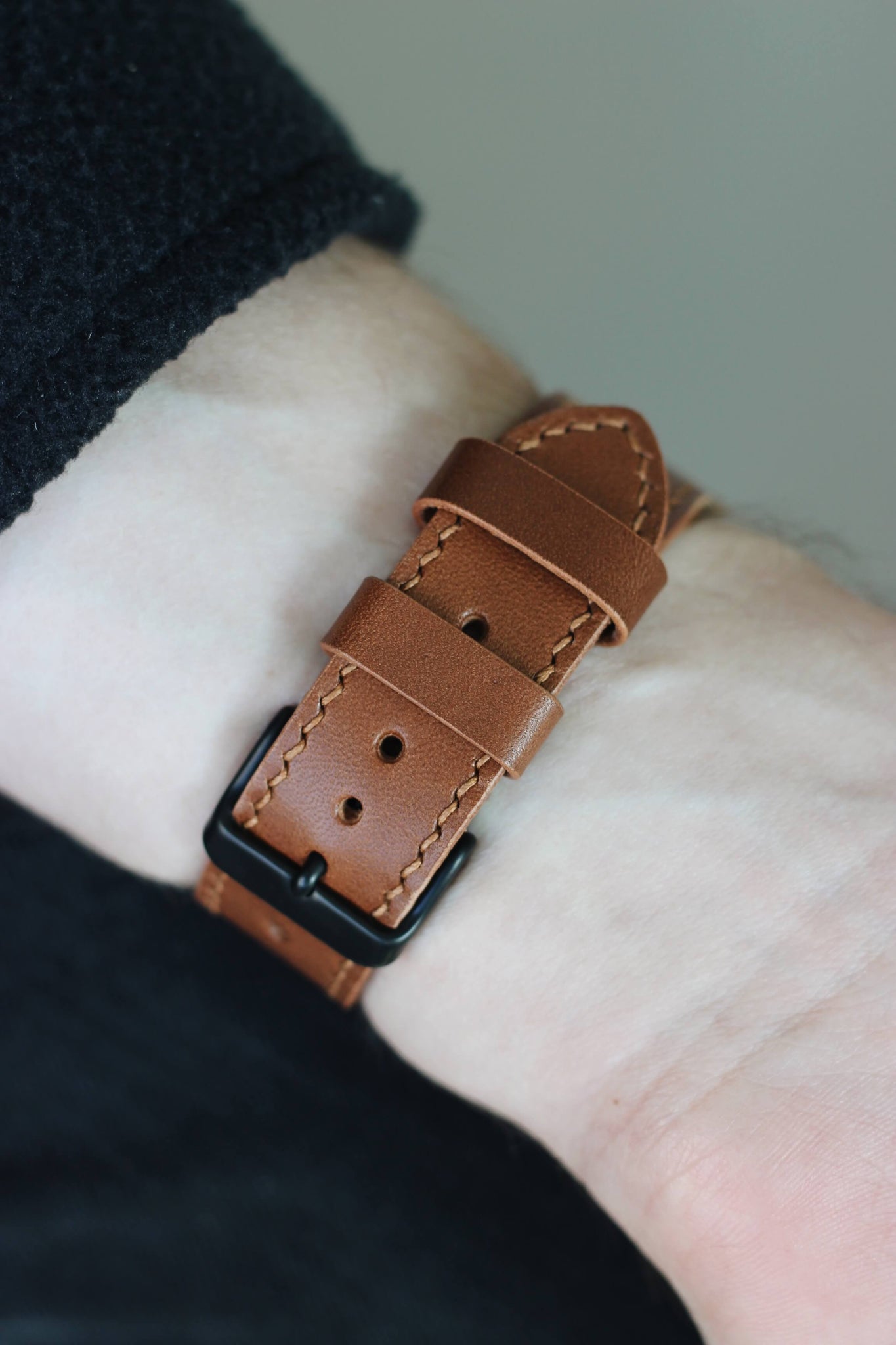 Apple Watch Lederarmband in Braun am Handgelenk von unten.