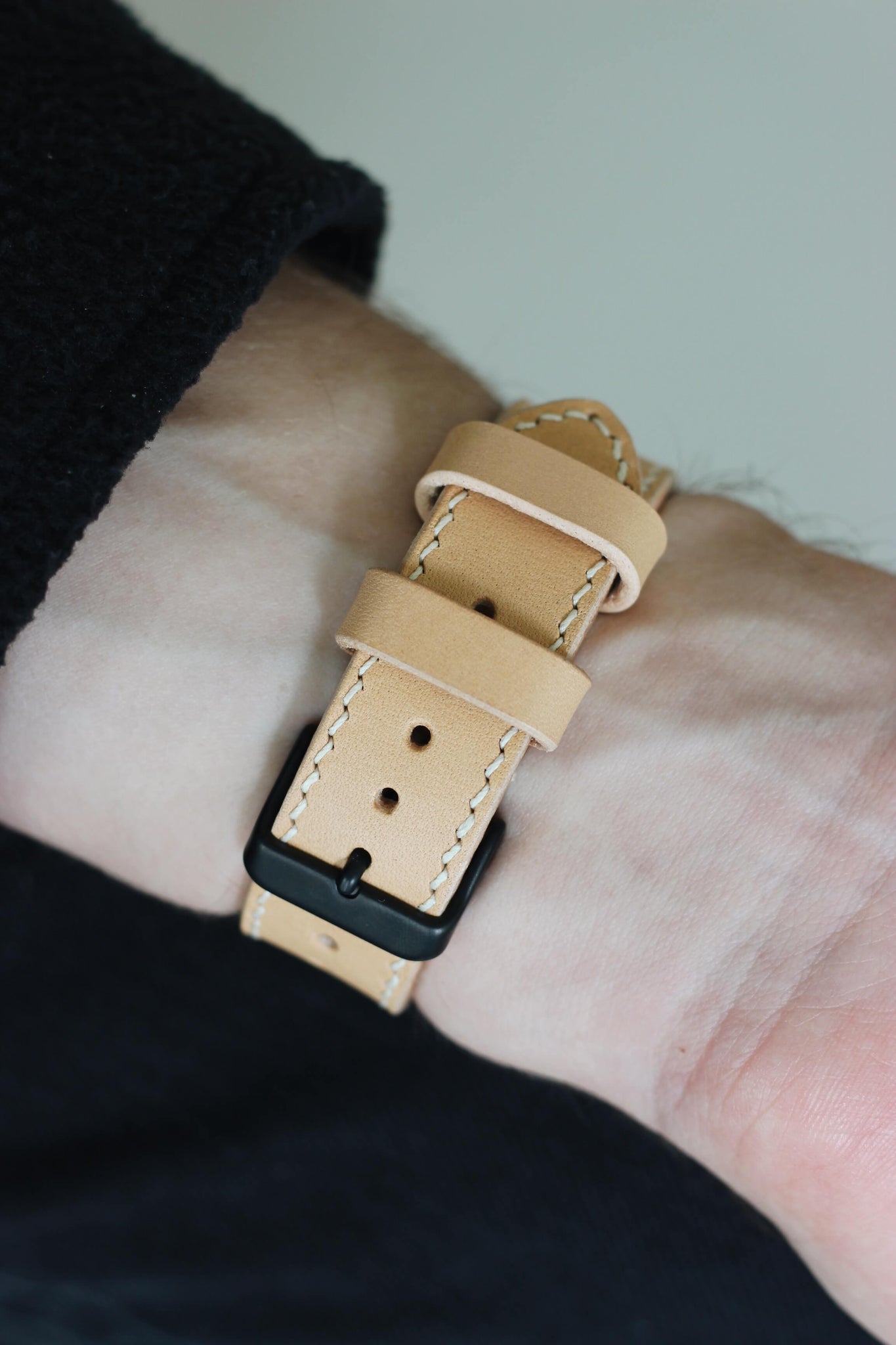 Apple Watch Lederarmband in Natural am Handgelenk von unten.