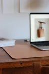 Ein aufgeklapptes MacBook steht auf einer Leder Schreibtischunterlage in Natural.