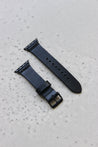 Apple Watch Lederband in Schwarz auf einem Betonuntergrund.