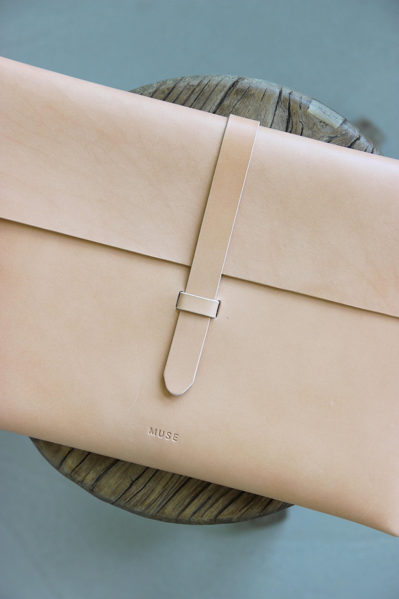 Nahaufnahme einer MacBook Hülle aus Leder in Natural auf einem auf Holzstuhl.