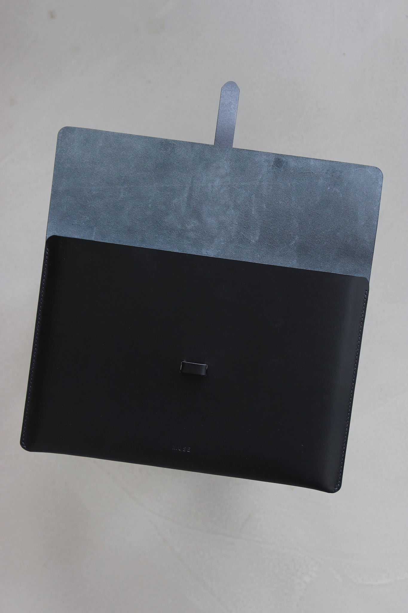 Eine aufgeklappte MacBook Hülle aus Leder in Schwarz.