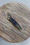 Ein Leder Schlüsselanhänger in Camo mit einem Karabiner und Schlüsselring in Messing Antik auf einem Holzstuhl.