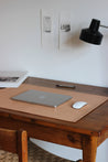 Seitliche Aufnahme einer Leder Schreibtischunterlage in Natural auf einem Schreibtisch.