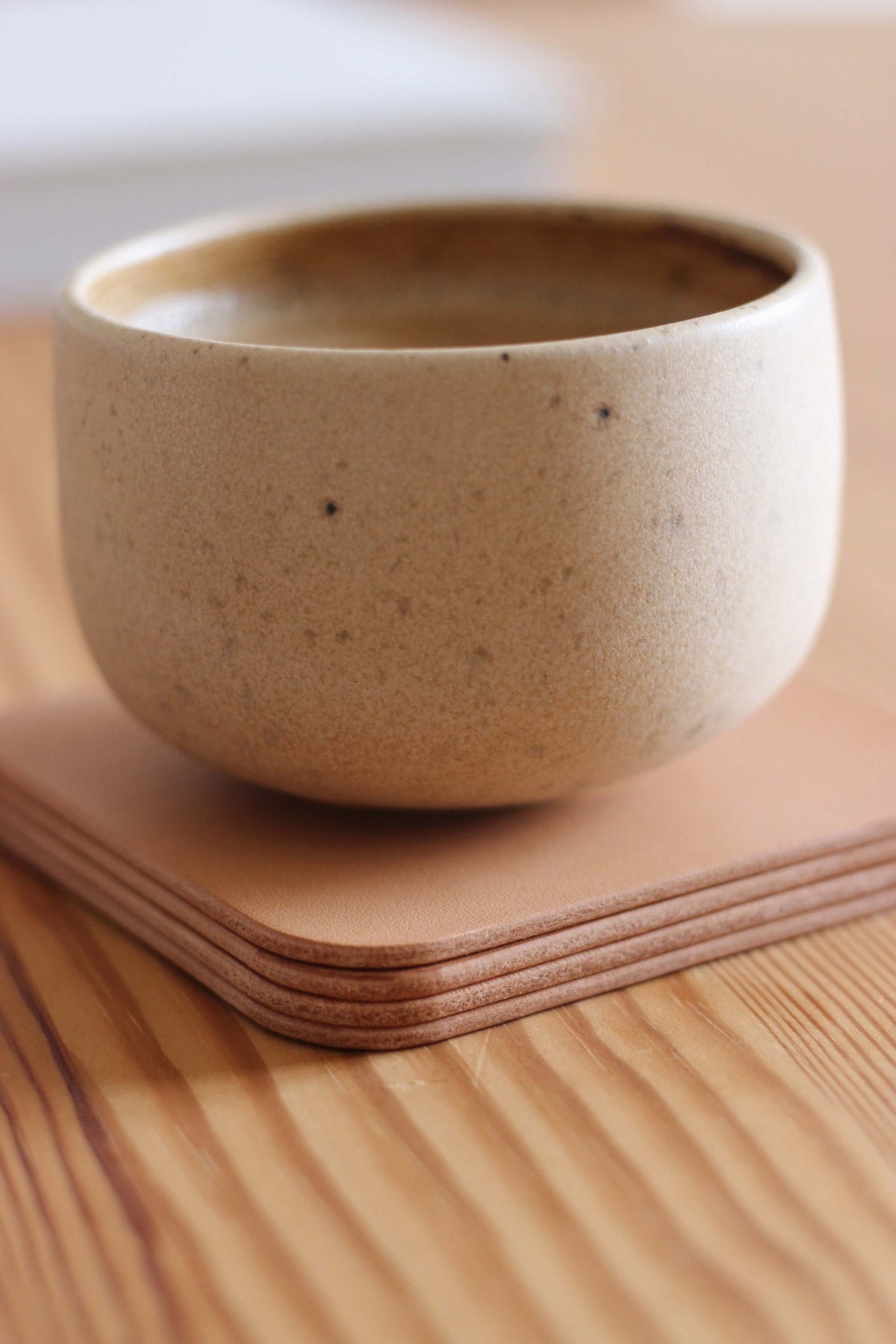 Auf einem Stapel Leder Untersetzer in Natur steht eine Kaffeetasse.